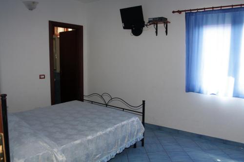 ein Schlafzimmer mit einem Bett und einem TV an der Wand in der Unterkunft HOTEL SANTA CLARA in Camerota