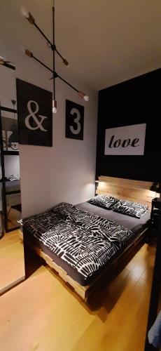 a bedroom with two beds with the words love on the wall at Apartament DANI in Nysa