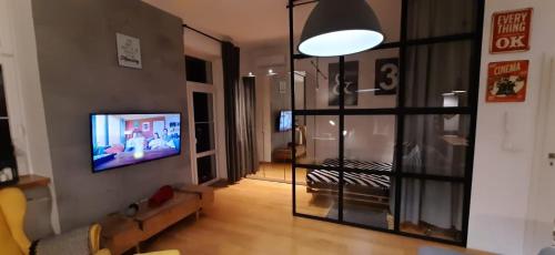 a living room with a television on a wall at Apartament DANI in Nysa