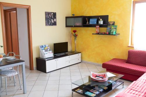 a living room with a couch and a tv at Terrazza baciata dal sole in Lazise