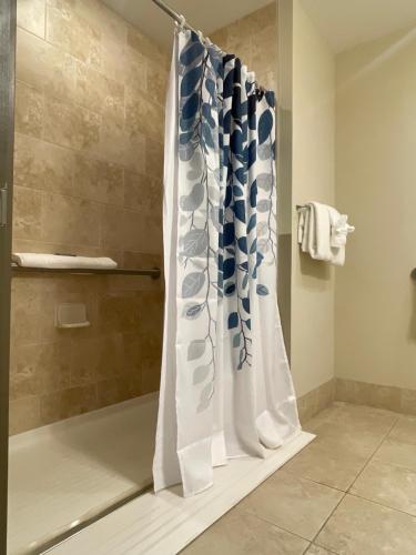 a bathroom with a shower with a shower curtain at South Beach Biloxi Hotel & Suites in Biloxi