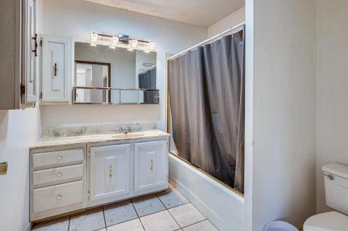 a bathroom with a sink and a mirror at Historic Wheeling Condo with Fireplace Near Museums! in Wheeling