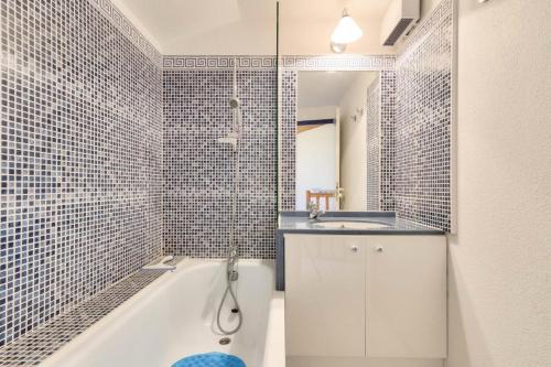 une salle de bain avec une baignoire blanche et un lavabo dans l'établissement Résidence Port Bourgenay - maeva Home - Appartement 3 pièces 6 personnes - Sélection MAE-9084, à Talmont-Saint-Hilaire