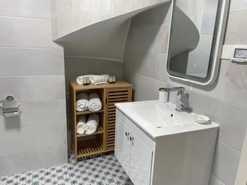 ein Badezimmer mit Waschbecken und Spiegel in der Unterkunft Yellow House Suite in Madschdal Schams