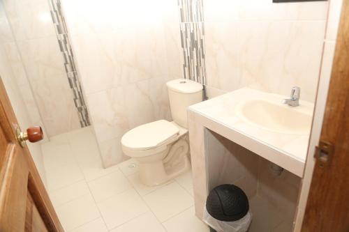uma casa de banho com um WC, um chuveiro e um lavatório. em Hotel Caribe Coveñas em Coveñas
