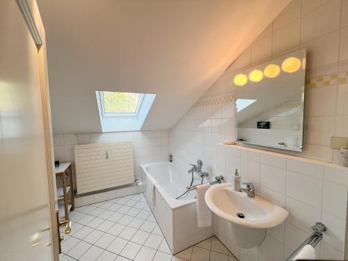 ein Badezimmer mit einem Waschbecken und einer Badewanne in der Unterkunft 8 Personen I BBQ I Sunset in Herrsching am Ammersee