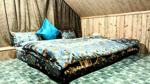 a bedroom with a bed with an orange comforter at MOKSHA COTTAGES AND WOODHOUSE in Kasol