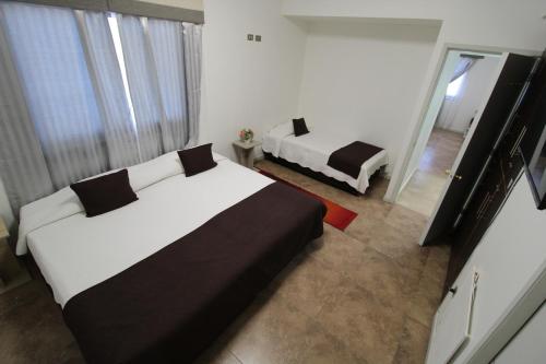 Habitación de hotel con 2 camas y espejo en Juku Hostal en Calama