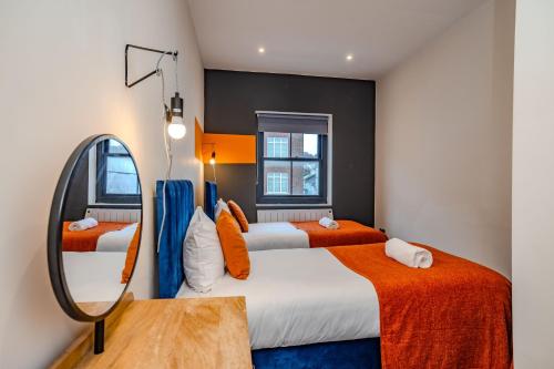 ein Hotelzimmer mit 2 Betten und einem Spiegel in der Unterkunft 3 Bedroom 2 Bathroom I Super Central Location I Sleep 9 Guests in Brighton & Hove
