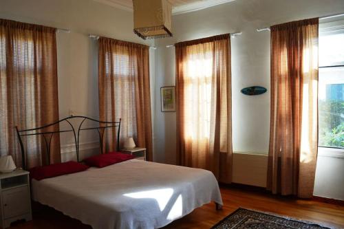 a bedroom with a bed and a large window at Vasiliki's House in Mytilene