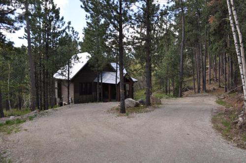 a small cabin in the middle of a dirt road at Gold Rush Lodge in Lead