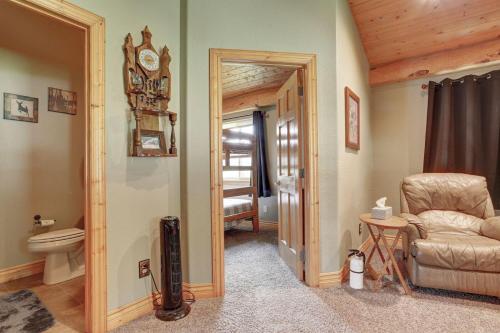 a bathroom with a toilet and a chair and a clock at Elk Creek Retreat in Lead