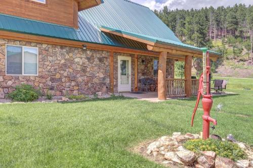 a stone house with a red fire hydrant in the yard at Elk Creek Retreat in Lead