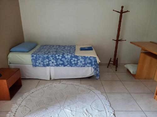 een kleine kamer met 2 bedden en een kruis aan de muur bij Espaço Verona apartamento econômico c/banheiro e sem café p/ 1 pessoa in Fazenda Rio Grande