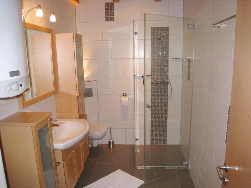 a bathroom with a shower and a toilet and a sink at Holiday home Haus Mewa in Neuenkirchen