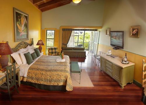 a bedroom with a large bed and a living room at Hotel Casa Turire in Turrialba