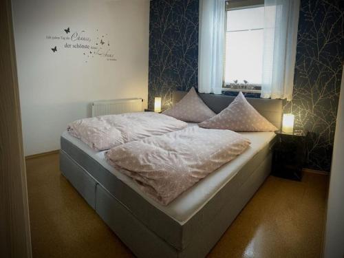 een slaapkamer met een groot bed en een raam bij Holiday apartment Resch in Perlesreut