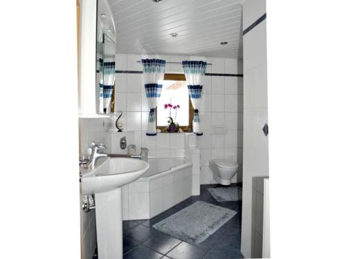 een badkamer met een wastafel, een bad en een toilet bij Holiday apartment Resch in Perlesreut