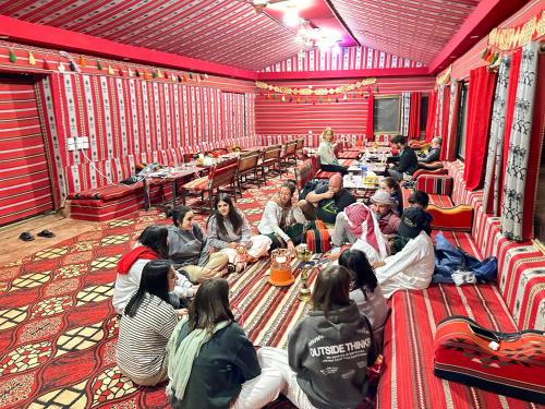 a group of people sitting on the floor in a room at Sunset Dreams camp in Wadi Rum