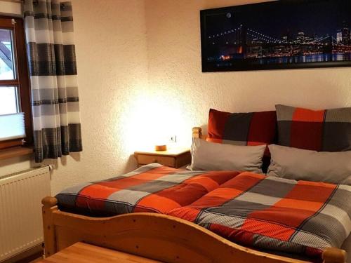 a bedroom with a bed with an orange and black comforter at Holiday home Wide in Eppenschlag