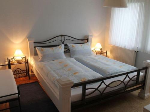 a bedroom with a large bed with two lamps at Bohn - Apartment 2 in Gersfeld