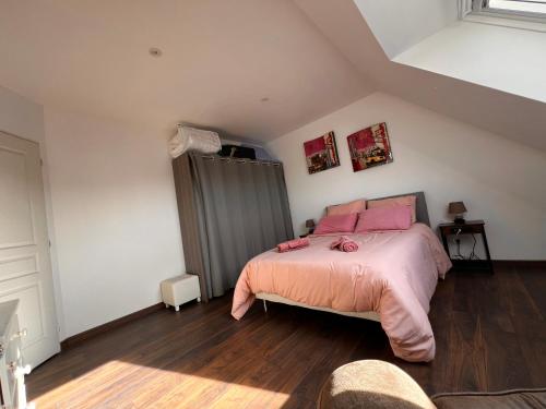 a bedroom with a bed with pink sheets and pink pillows at Maison chaleureuse tout confort in Amboise