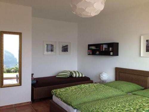 a bedroom with two green beds and a mirror at Holiday apartment Rursee in Simmerath