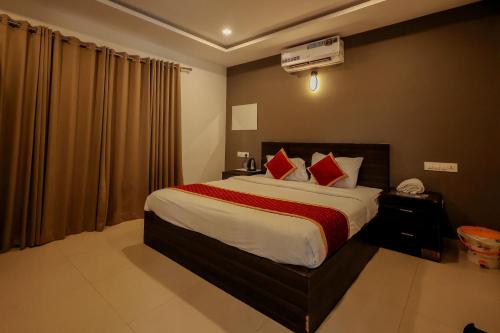 a bedroom with a large bed with red pillows at Konfudha Resort in Kalpetta