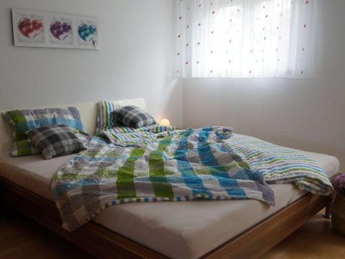 a bed with a blanket and pillows on it at Holiday apartment holidays in the forest in Weisenbach