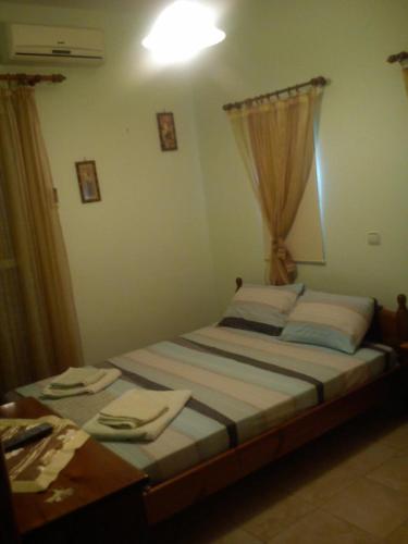 a bedroom with a bed and a window at Argoliki Thalassa in Míloi