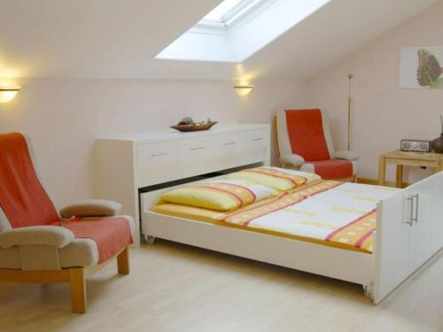a bedroom with a bed and two chairs at Holiday apartment Gelting in Gelting