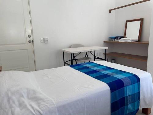 a bedroom with a bed and a table and a mirror at Casa Maya en el mejor lugar de Puerto Escondido in Puerto Escondido