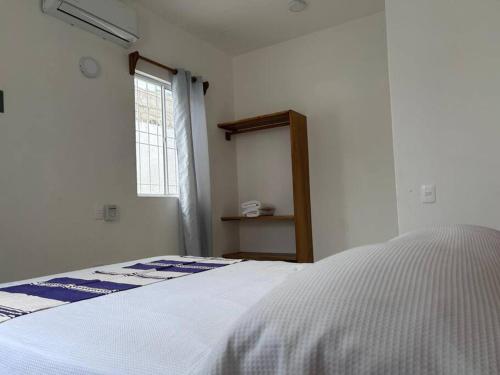 a bedroom with a white bed and a window at Casa Maya en el mejor lugar de Puerto Escondido in Puerto Escondido