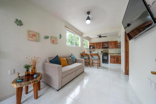 a living room with a couch and a table at Villas EVA - Zihuatanejo in Zihuatanejo