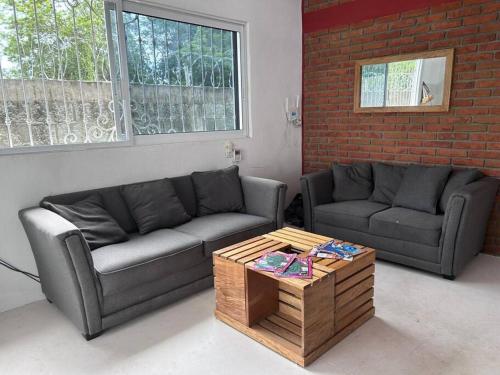 a living room with two couches and a coffee table at Casa Maya en el mejor lugar de Puerto Escondido in Puerto Escondido