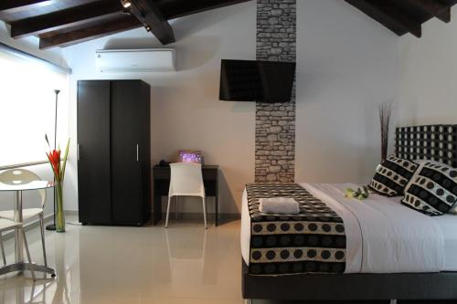 a bedroom with a bed and a desk with a chair at La Cabrera Hotel Boutique in Neiva
