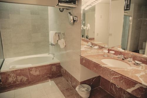 a bathroom with two sinks and a tub and a mirror at Haywood Park Hotel, an Ascend Collection Hotel in Asheville