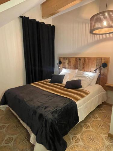 a bedroom with a large bed with black curtains at REFUGE DU CAP in Saint-Lary-Soulan