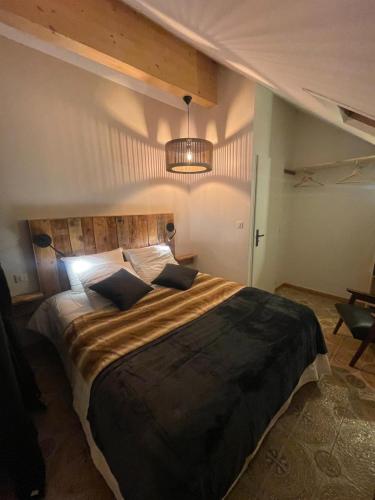 une chambre avec un grand lit avec une tête de lit en bois dans l'établissement REFUGE DU CAP, à Saint-Lary-Soulan