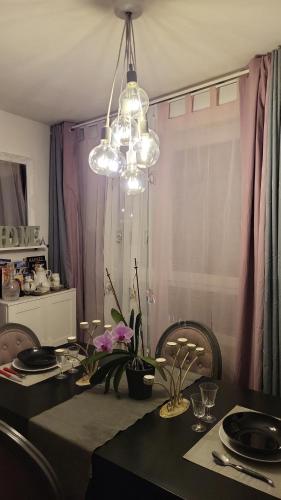 une salle à manger avec une table et un lustre dans l'établissement IL & DG Services, à Saint-Denis