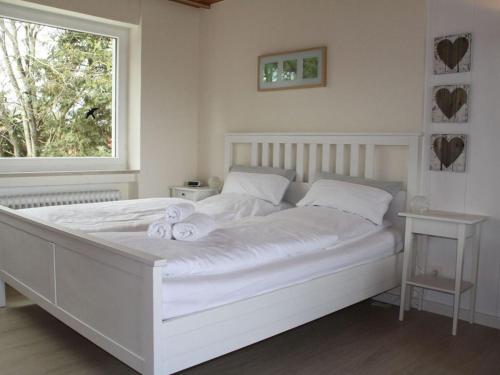 białe łóżko z ręcznikami w sypialni w obiekcie Landhaus Säntisweg - "Hochgrat" w mieście Oberreute