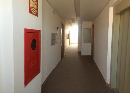 a hallway with a red door and a hallway with a corridorngthngthngthngth at Lord Hotel Aeroporto Confins in Vespasiano