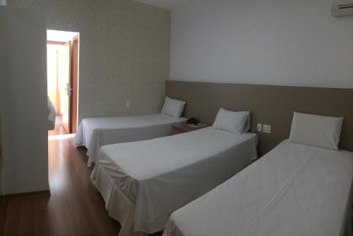 a hotel room with two beds and a window at Lord Hotel Aeroporto Confins in Vespasiano