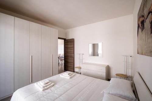 a white bedroom with a bed and a window at Casa Trekking Salento Marittima Di Diso in Marittima