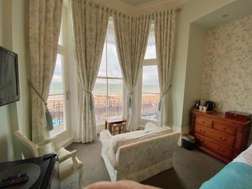 a bedroom with a large window with a view of the ocean at East Beach Hotel in Eastbourne