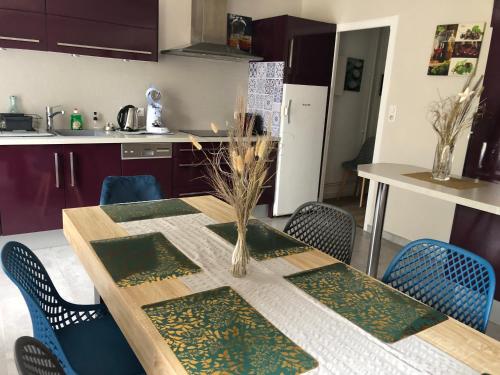 una cocina con mesa con sillas azules y una cocina con mesa en Maison de caractère proche centre ville et termes, en Bourbonne-les-Bains