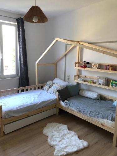 une chambre avec deux lits superposés et une fenêtre dans l'établissement Maison de caractère proche centre ville et termes, à Bourbonne-les-Bains