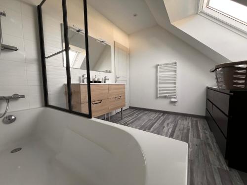 a bathroom with a large white tub and a sink at Maison chaleureuse tout confort in Amboise