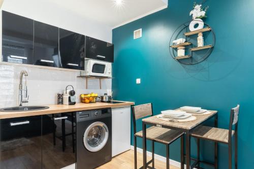une cuisine avec une machine à laver et une table dans l'établissement New - L'Azura - Qualité Premium - Balcon en hypercentre - insonorisation maximisée, à Nantes