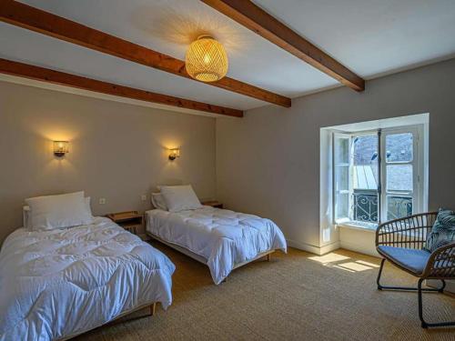 une chambre avec deux lits et une fenêtre dans l'établissement Gîte Ty Maen à Plouhinec 56 7pers, à Plouhinec